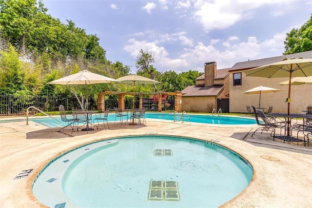 pool with a patio and fence