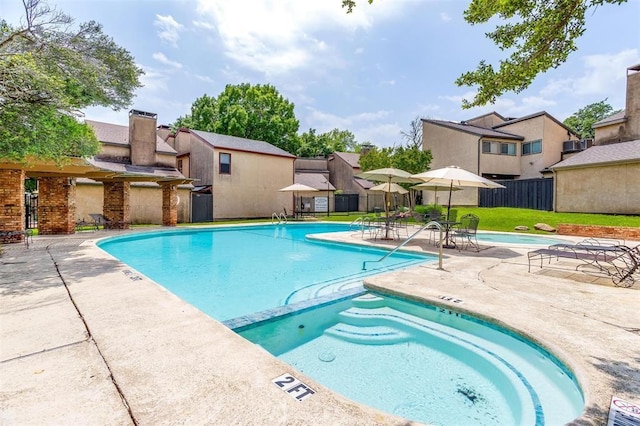 community pool featuring a patio, fence, a residential view, and a lawn