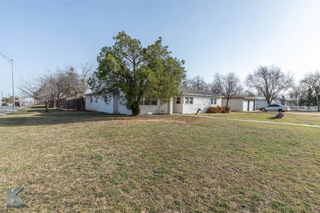 ranch-style home with a garage, a front yard, and fence