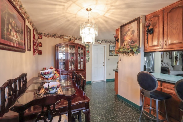 dining area with a chandelier and baseboards