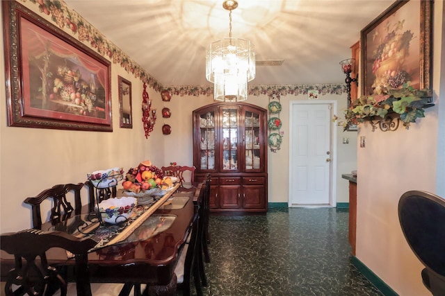 dining room with a chandelier and baseboards