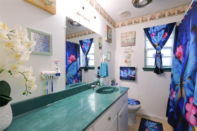 full bath with toilet, baseboards, a wealth of natural light, and vanity