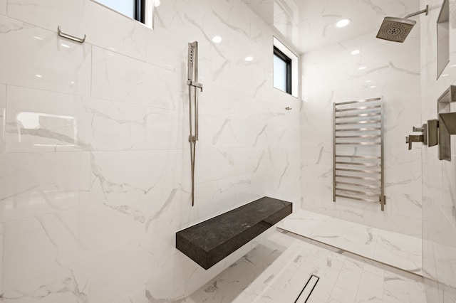 bathroom featuring a marble finish shower, marble finish floor, stone wall, and radiator heating unit