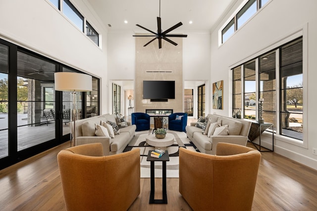 living room featuring wood finished floors, ceiling fan, and a tile fireplace