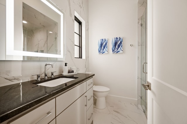 full bath with a marble finish shower, baseboards, toilet, marble finish floor, and vanity