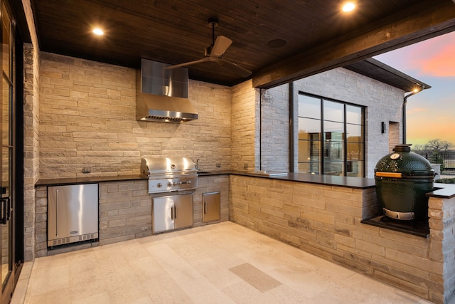 patio terrace at dusk featuring exterior kitchen, a ceiling fan, and a grill