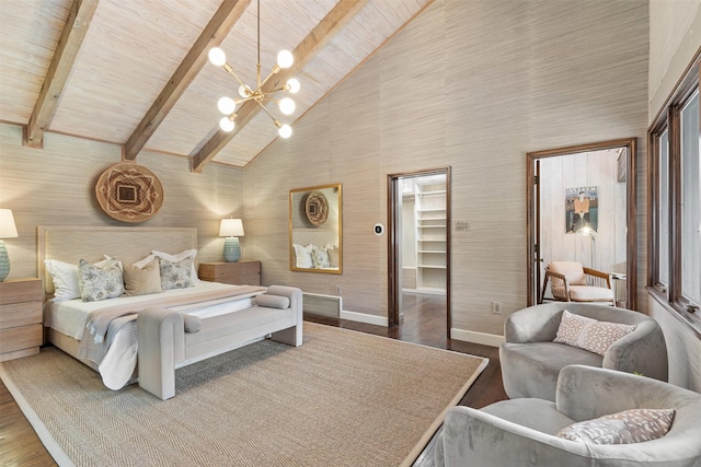 bedroom with beam ceiling, baseboards, and wood finished floors