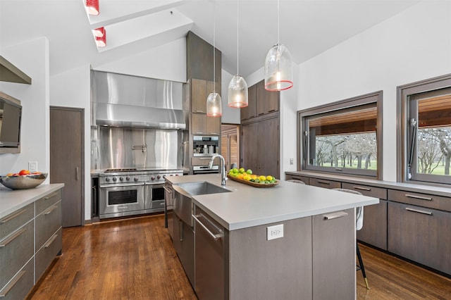 kitchen with light countertops, decorative backsplash, appliances with stainless steel finishes, wall chimney range hood, and modern cabinets