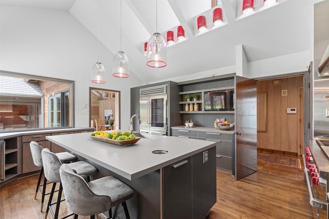 kitchen with dark wood-style floors, light countertops, modern cabinets, and a kitchen island with sink