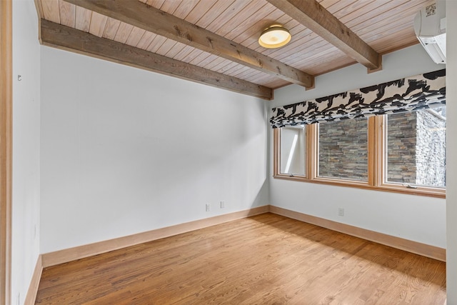 empty room featuring baseboards, wooden ceiling, wood finished floors, an AC wall unit, and beam ceiling