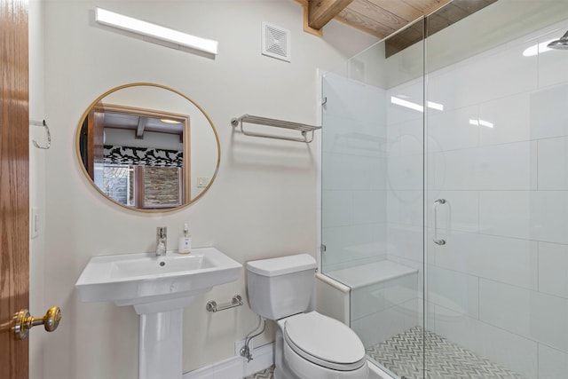 full bath featuring toilet, a stall shower, visible vents, and baseboards