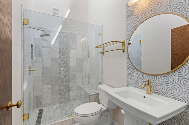 bathroom with visible vents, a sink, toilet, and tiled shower