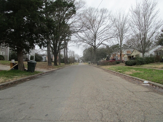 view of road with a residential view and curbs