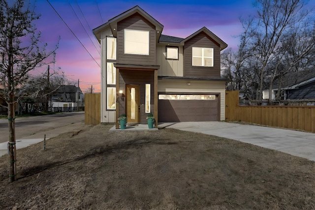 view of front of home featuring a garage, concrete driveway, fence, and board and batten siding