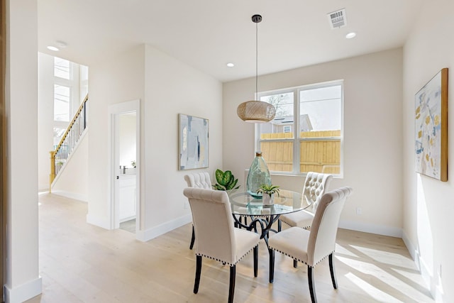 dining space with light wood finished floors, recessed lighting, visible vents, and baseboards