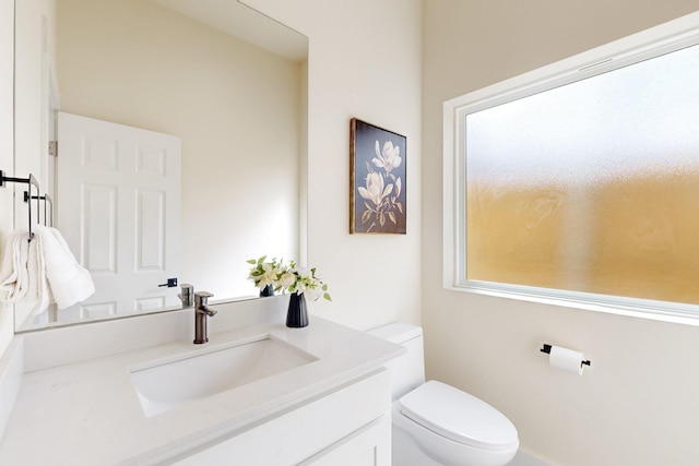 half bathroom with vanity and toilet