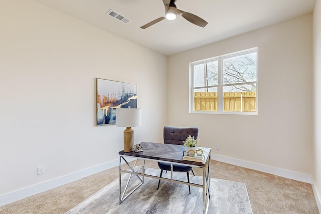 carpeted office space with a ceiling fan, baseboards, and visible vents