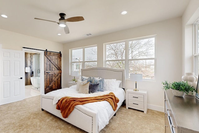 bedroom featuring light carpet, a barn door, visible vents, and recessed lighting