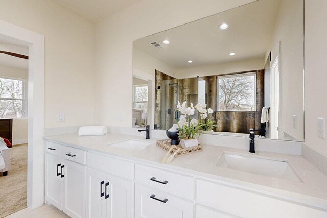 bathroom featuring recessed lighting, a sink, baseboards, and double vanity