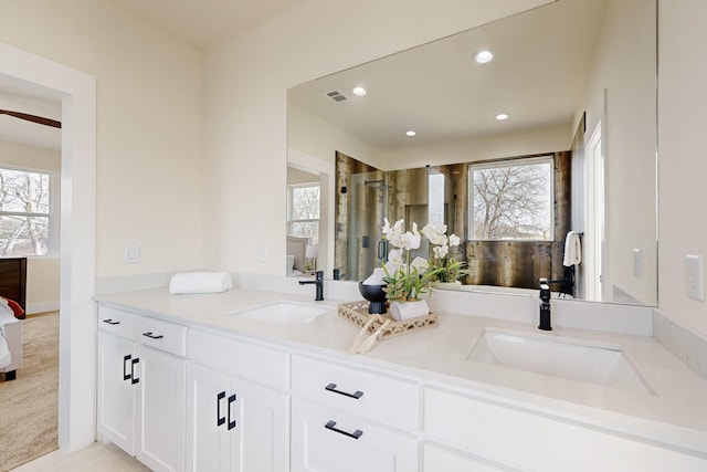 full bath with ensuite bathroom, a sink, and plenty of natural light