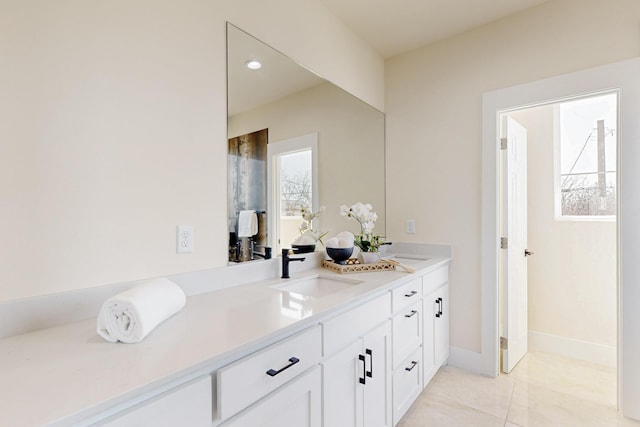 full bathroom with double vanity, recessed lighting, baseboards, and a sink