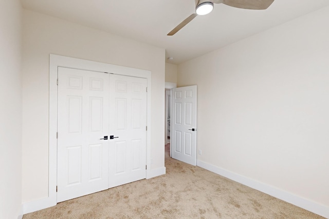 unfurnished bedroom with a ceiling fan, a closet, baseboards, and carpet flooring