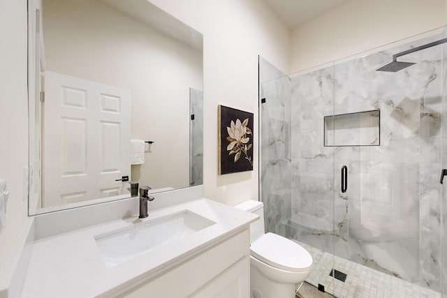 bathroom featuring toilet, vanity, and a marble finish shower