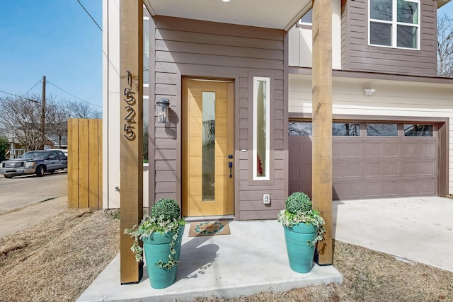 view of exterior entry featuring concrete driveway and an attached garage