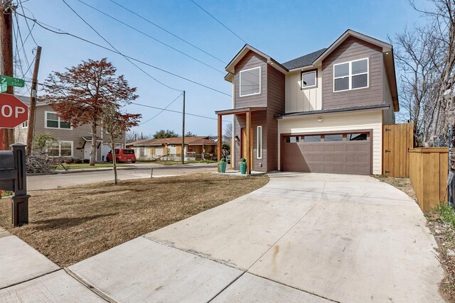 view of front of home featuring board and batten siding, driveway, a garage, and fence