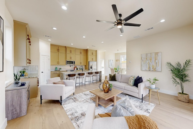 living room with recessed lighting, visible vents, and light wood-style flooring