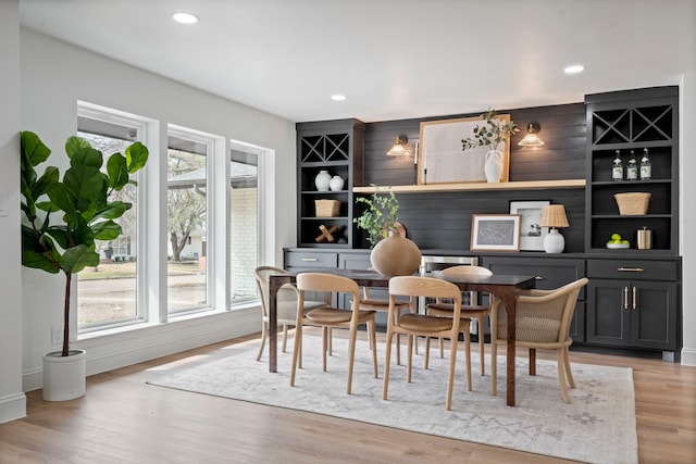 dining room featuring light wood finished floors, built in features, and recessed lighting