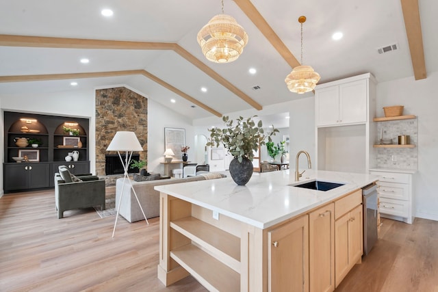 kitchen featuring lofted ceiling with beams, a sink, visible vents, stainless steel dishwasher, and open shelves