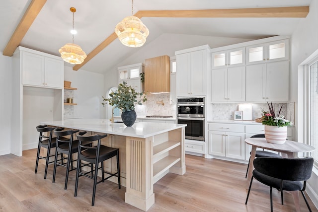 kitchen featuring light wood-style floors, open shelves, stainless steel double oven, and light countertops