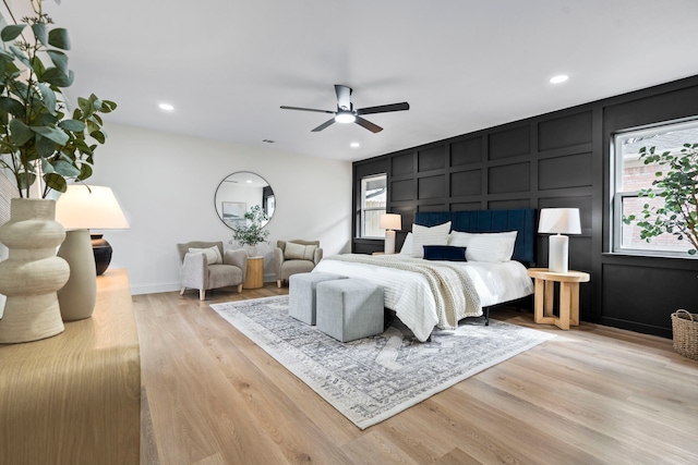 bedroom featuring recessed lighting, wood finished floors, and a decorative wall