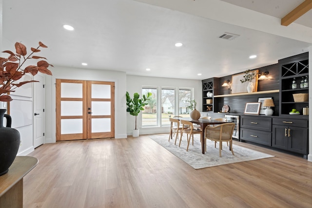 dining room featuring french doors, wine cooler, visible vents, and light wood-style floors