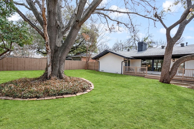 view of yard with a deck and fence