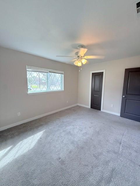 unfurnished bedroom featuring carpet, a ceiling fan, and baseboards