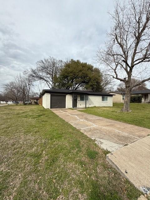 view of front of house with driveway, a garage, and a front yard