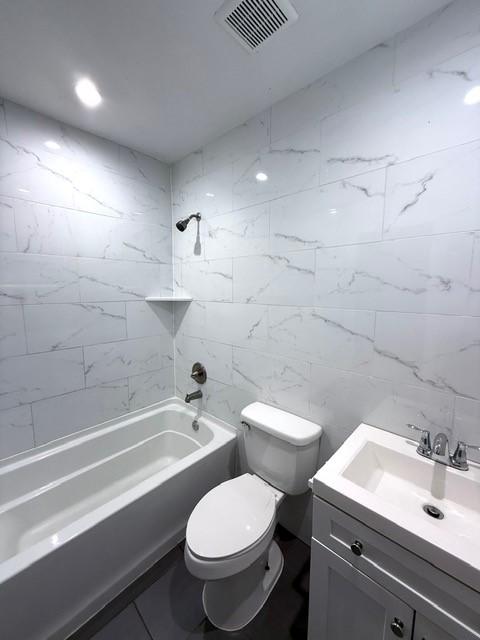 full bath featuring toilet, washtub / shower combination, visible vents, and vanity