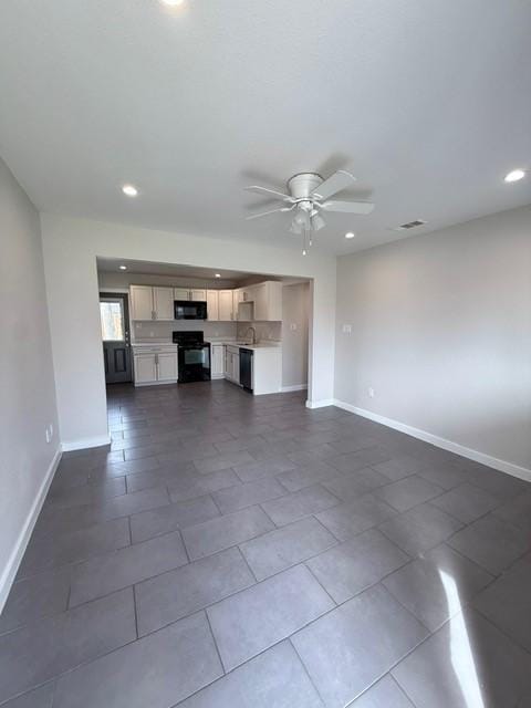 unfurnished living room with a ceiling fan, recessed lighting, dark tile patterned flooring, and baseboards