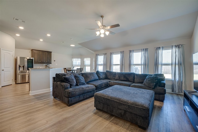 living area with lofted ceiling, visible vents, light wood-style flooring, and recessed lighting