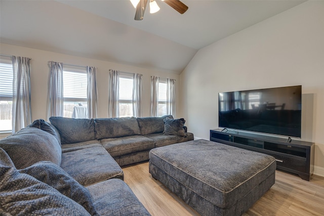 living room featuring lofted ceiling, light wood finished floors, ceiling fan, and baseboards