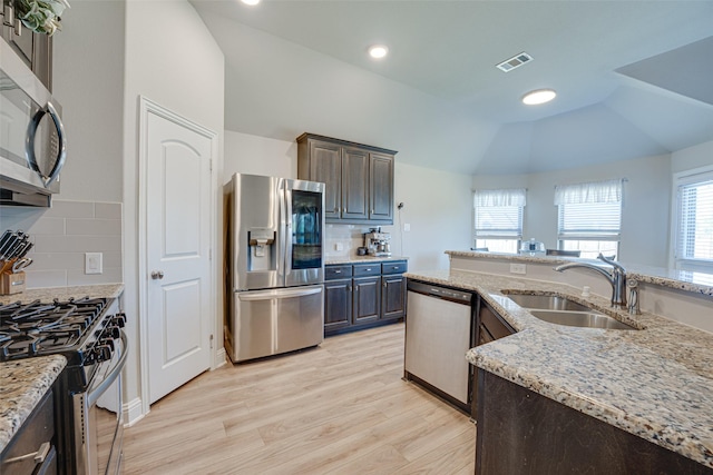 kitchen featuring light wood finished floors, visible vents, lofted ceiling, appliances with stainless steel finishes, and a sink