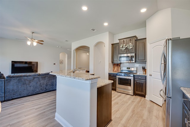 kitchen featuring appliances with stainless steel finishes, light wood-type flooring, open floor plan, and visible vents