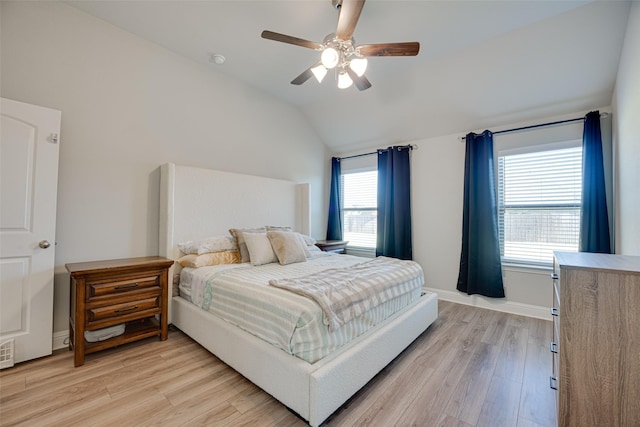 bedroom featuring lofted ceiling, light wood-style floors, baseboards, and a ceiling fan