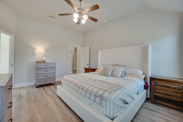 bedroom featuring lofted ceiling, light wood-style flooring, visible vents, and baseboards