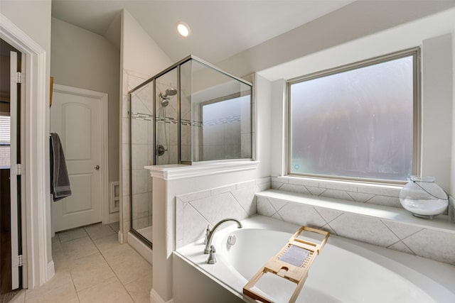 full bathroom featuring lofted ceiling, a stall shower, a garden tub, and tile patterned floors