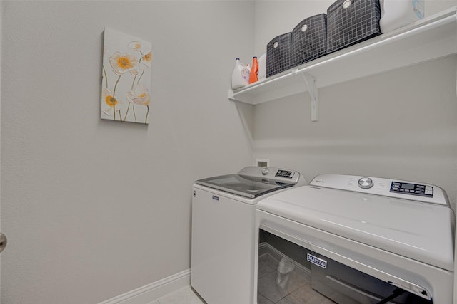 laundry room featuring laundry area, tile patterned flooring, washing machine and clothes dryer, and baseboards