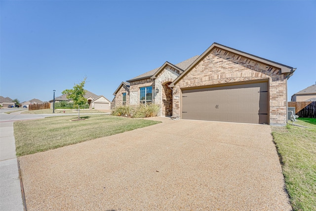 french country style house featuring brick siding, a front yard, fence, a garage, and driveway