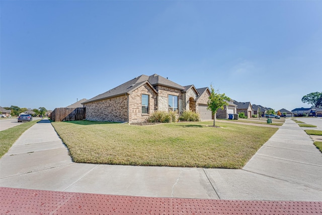 view of front facade featuring a front yard, brick siding, fence, and a residential view